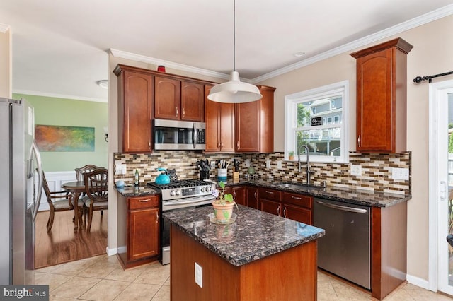 5930 Copper Mountain Dr W, Spotsylvania, VA 22553 - kitchen with stainless steel appliances, a sink, ornamental molding, a kitchen island, and dark stone counters