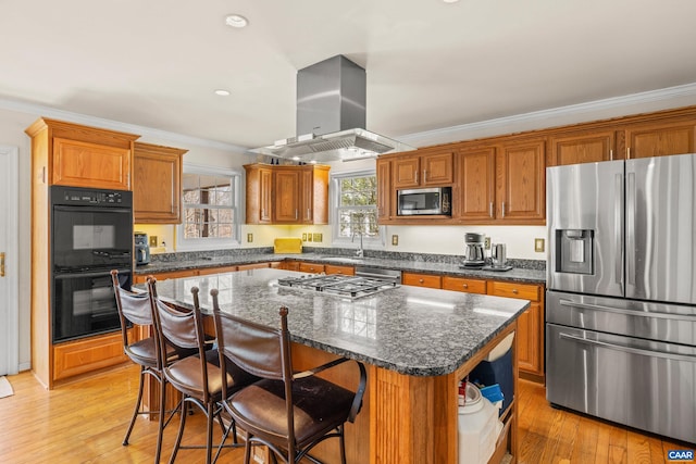 56 Wildwood Dr, Palmyra, VA 22963 - kitchen with appliances with stainless steel finishes, extractor fan, crown molding, brown cabinets, and a kitchen island