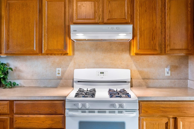 816 Rutherford St, Staunton, VA 24401 - kitchen with white range with gas cooktop, under cabinet range hood, light countertops, and decorative backsplash
