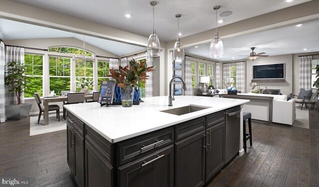 kitchen with a sink, light countertops, open floor plan, and a ceiling fan