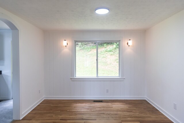 164 28th St E, Buena Vista, VA 24416 - unfurnished room with wood finished floors, arched walkways, and a textured ceiling