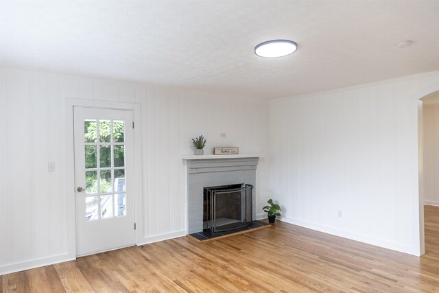 164 28th St E, Buena Vista, VA 24416 - unfurnished living room featuring light wood-type flooring, a brick fireplace, and arched walkways