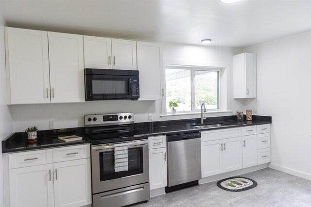 164 28th St E, Buena Vista, VA 24416 - kitchen featuring appliances with stainless steel finishes, white cabinetry, and dark countertops