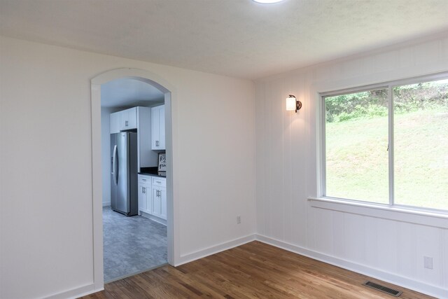 164 28th St E, Buena Vista, VA 24416 - empty room with arched walkways, wood finished floors, and plenty of natural light
