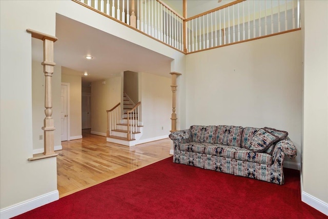 114 Meagans Run Rd, Woodstock, VA 22664 - carpeted living area featuring stairs, wood finished floors, and a towering ceiling