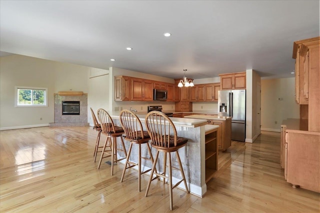 114 Meagans Run Rd, Woodstock, VA 22664 - kitchen with appliances with stainless steel finishes, a chandelier, light wood-style flooring, light countertops, and a breakfast bar