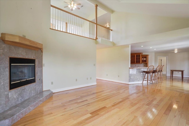 114 Meagans Run Rd, Woodstock, VA 22664 - unfurnished living room with light wood-type flooring, a high end fireplace, high vaulted ceiling, ceiling fan, and beamed ceiling