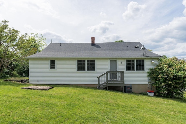 back of property featuring a chimney, a lawn, and central AC