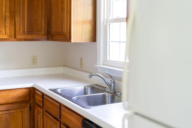 kitchen with a sink, brown cabinets, and light countertops
