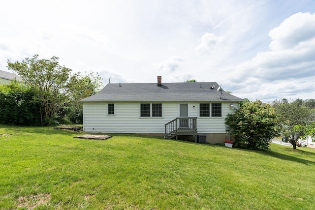 back of property featuring a lawn, a chimney, and central air condition unit