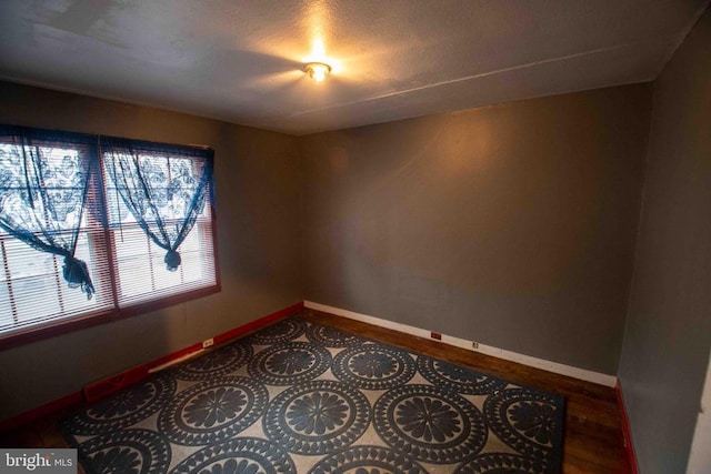 spare room with baseboards