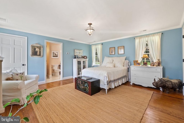  - bedroom with ornamental molding, visible vents, and wood finished floors