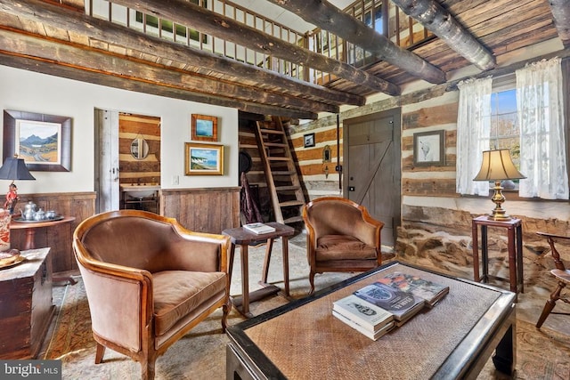  - sitting room featuring a wainscoted wall, beam ceiling, and wooden walls