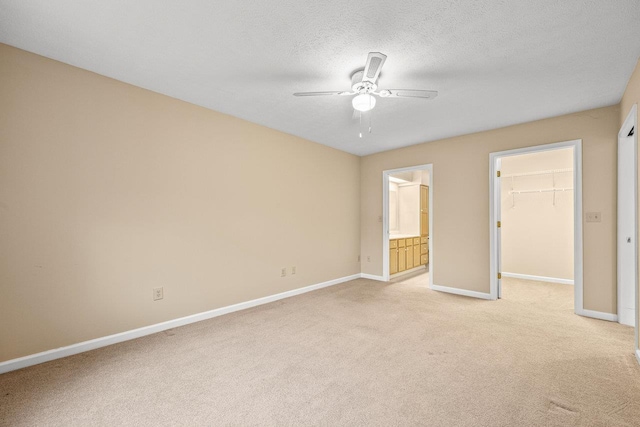 127 Emerald Dr, Harrisonburg, VA 22801 - unfurnished bedroom featuring light colored carpet, baseboards, a walk in closet, a closet, and a textured ceiling
