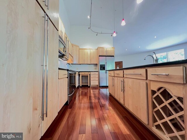 243 Aaron Mountain Rd, Castleton, VA 22716 - kitchen featuring appliances with stainless steel finishes, light brown cabinets, beverage cooler, dark countertops, and dark wood-style flooring