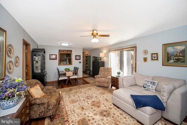 living room featuring ceiling fan, wood finished floors, and baseboards