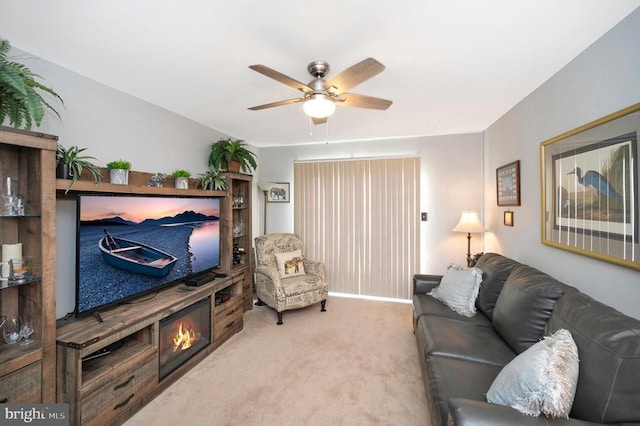 living area with a ceiling fan and light carpet