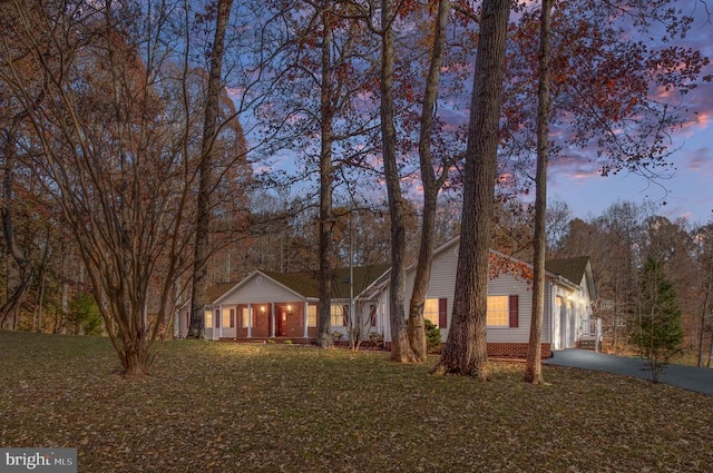 ranch-style house featuring a garage, a yard, and a porch