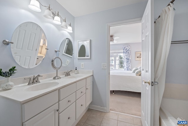 ensuite bathroom with double vanity, tile patterned floors, connected bathroom, and a sink