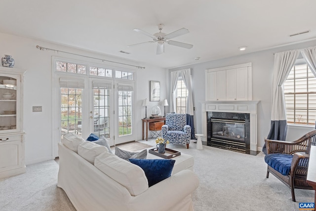 living area featuring a fireplace, baseboards, ceiling fan, light colored carpet, and recessed lighting