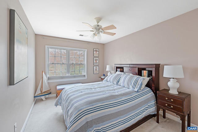 bedroom featuring light colored carpet, visible vents, baseboards, and a ceiling fan