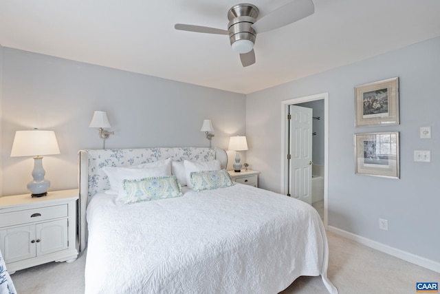 bedroom featuring baseboards, ensuite bath, a ceiling fan, and light colored carpet