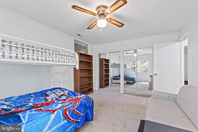  - carpeted bedroom with two closets and ceiling fan