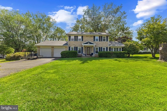 - colonial inspired home with a garage, driveway, brick siding, and a front lawn