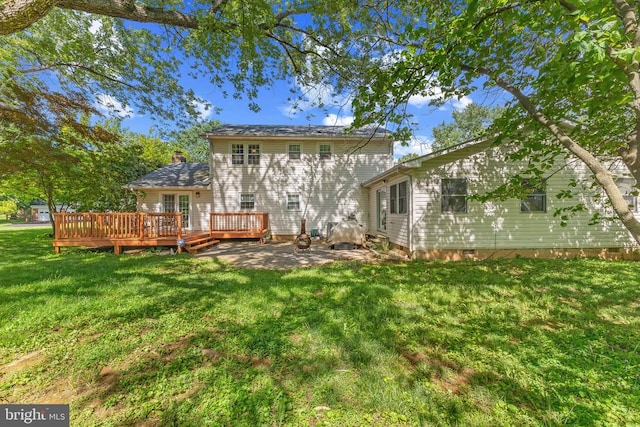  - back of house with a wooden deck and a yard