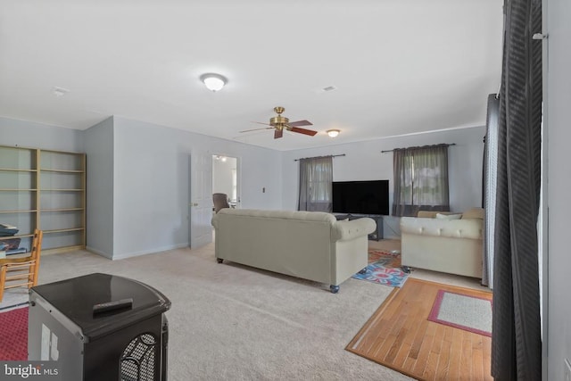  - living area with a ceiling fan, carpet, and baseboards