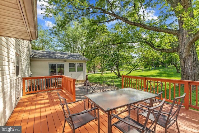 - wooden deck featuring outdoor dining area and a yard