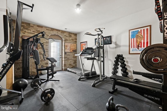  - workout area featuring arched walkways and brick wall