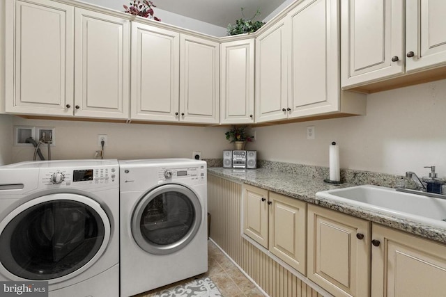  - washroom with cabinet space, washing machine and dryer, and light tile patterned floors
