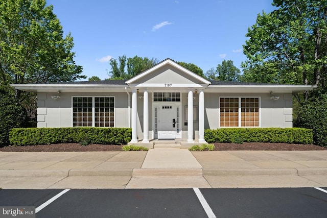  - view of front of house featuring uncovered parking and stucco siding