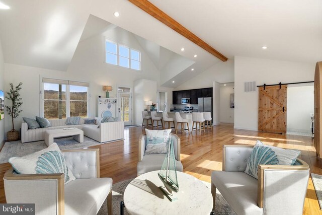  - living room featuring a barn door, light wood-type flooring, high vaulted ceiling, beamed ceiling, and recessed lighting