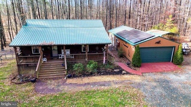 log cabin with a garage, an outbuilding, and covered porch