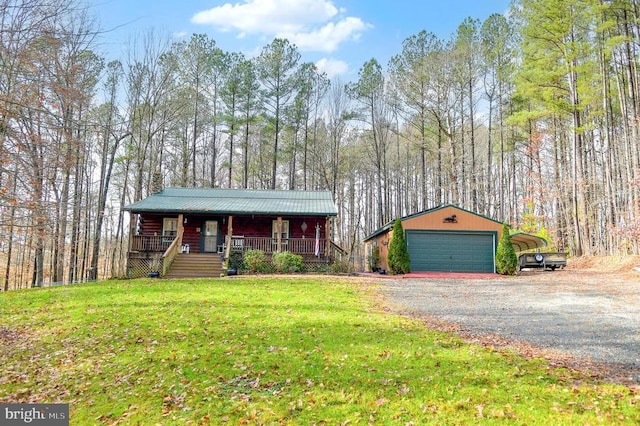 ranch-style house with covered porch, a front yard, a garage, and an outbuilding