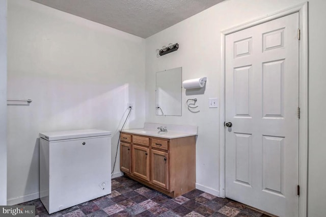 bathroom with vanity and a textured ceiling