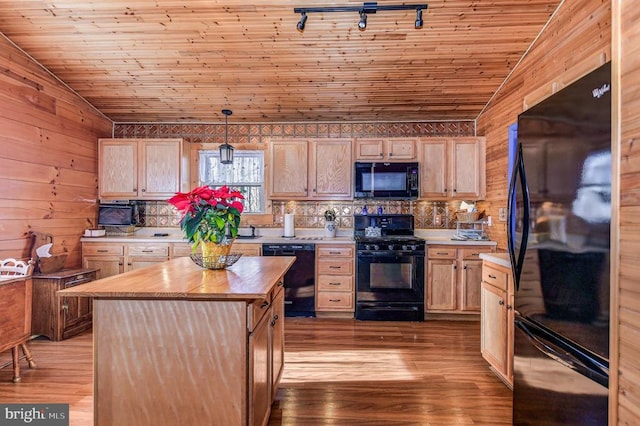 kitchen with hanging light fixtures, black appliances, and light brown cabinetry