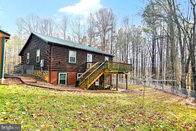 rear view of house featuring a lawn and a wooden deck