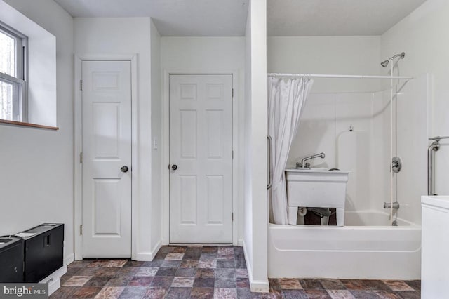 bathroom with shower / bathtub combination with curtain and sink