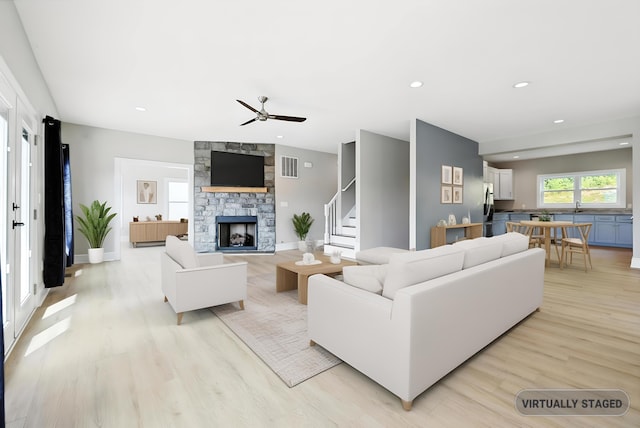43 Mcilwee Ln, Staunton, VA 24401 - living area with light wood finished floors, a stone fireplace, ceiling fan, stairway, and recessed lighting