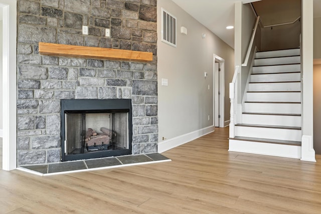 43 Mcilwee Ln, Staunton, VA 24401 - unfurnished living room with wood finished floors, a stone fireplace, and stairs
