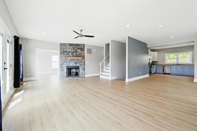 43 Mcilwee Ln, Staunton, VA 24401 - unfurnished living room featuring a ceiling fan, a stone fireplace, light wood-style flooring, stairway, and recessed lighting