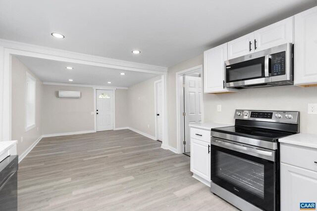 1805 Shenandoah Ave, Waynesboro, VA 22980 - kitchen featuring stainless steel appliances, light countertops, light wood finished floors, an AC wall unit, and white cabinets