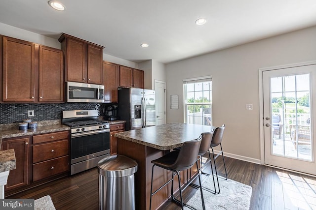 2015 Elm Tree Ct, Charlottesville, VA 22911 - kitchen with stainless steel appliances, dark wood-type flooring, dark countertops, a kitchen breakfast bar, and tasteful backsplash