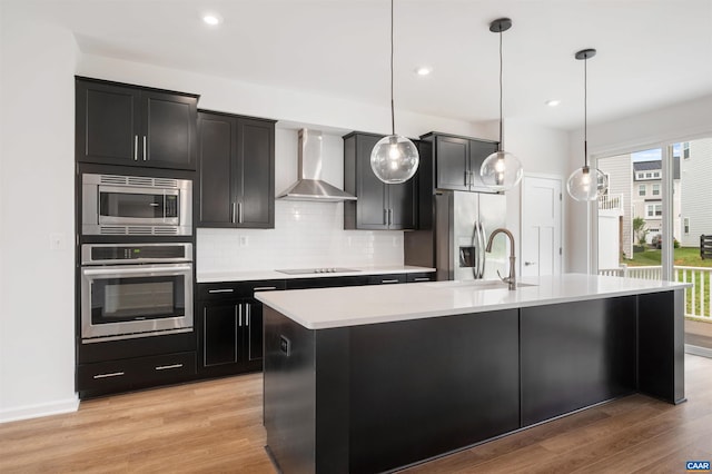 4454 Alston St, Crozet, VA 22932 - kitchen featuring appliances with stainless steel finishes, wall chimney range hood, a center island with sink, light countertops, and decorative backsplash