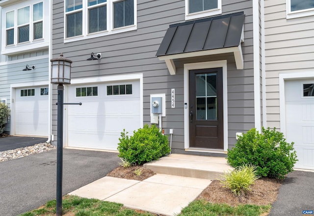 4454 Alston St, Crozet, VA 22932 - view of exterior entry with an attached garage, driveway, a standing seam roof, and a metal roof
