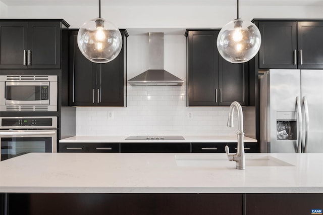 4454 Alston St, Crozet, VA 22932 - kitchen with wall chimney exhaust hood, appliances with stainless steel finishes, backsplash, decorative light fixtures, and dark cabinets