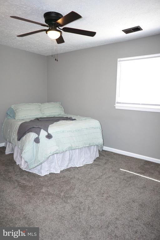 7435 Courthouse Rd, Spotsylvania, VA 22551 - carpeted bedroom featuring baseboards, a textured ceiling, and ceiling fan